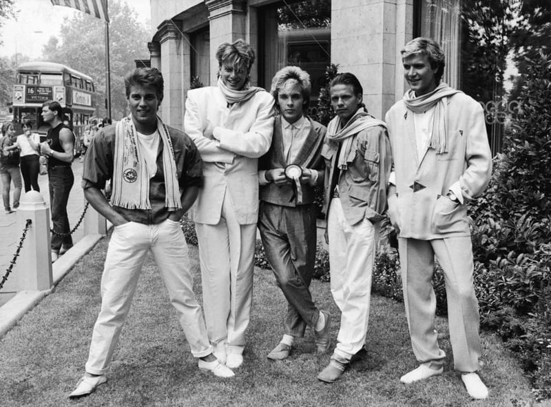 Duran Duran smile and laugh while posing on a lawn, England, c. 1983. (Photo by Express Newspapers/Getty Images)