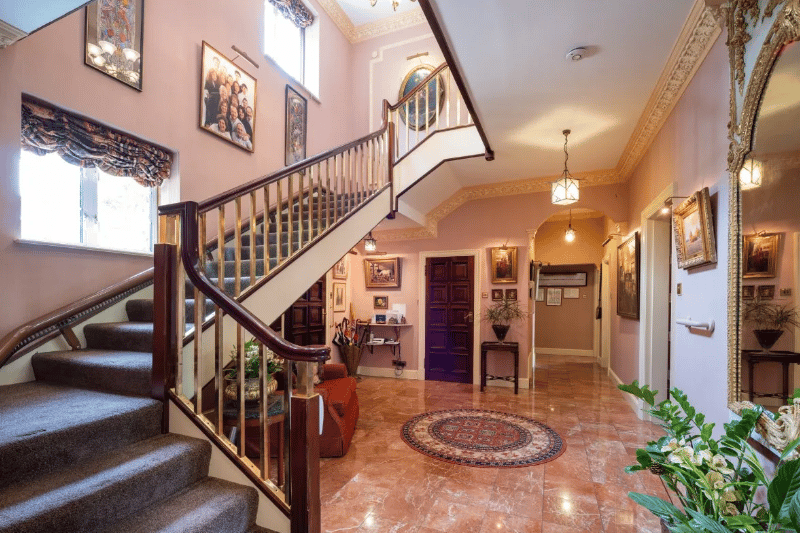 First shot of the inside, showcasing a huge staircase and large entrance