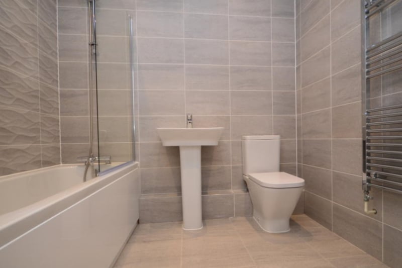 The property has a modern bathroom with heated towel rack, toilet, sink, bath and shower.