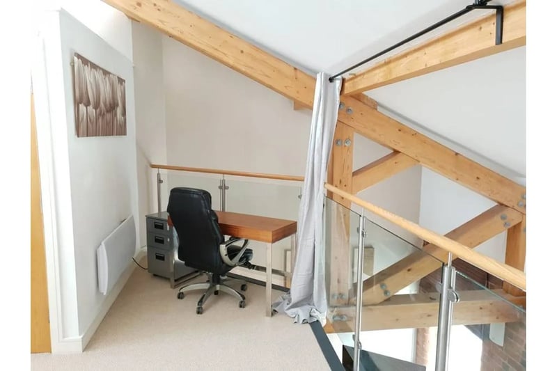 The top of the iron staircase houses a mezzanine space for a small home office for remote workers in Birmingham