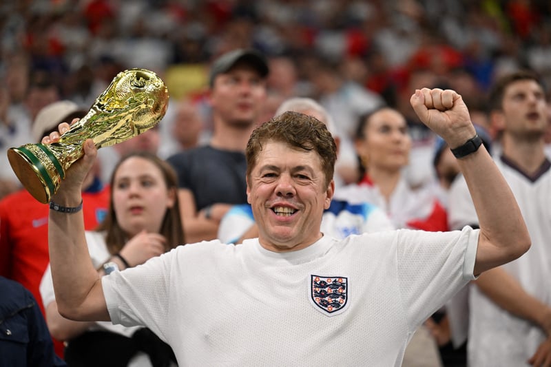 England supporter holding a replica of the World Cup trophy.
