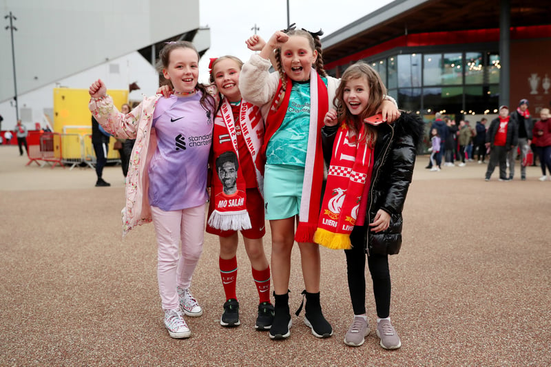 Young Liverpool fans pose for a photo outside Anfield ahead of the Merseyside derby on September 25, 2022.