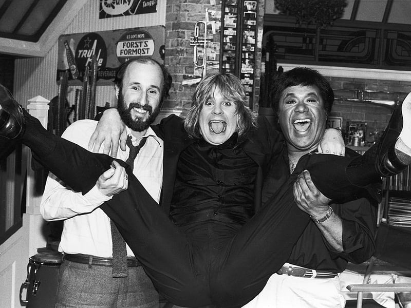 Ozzy Osbourne spreads his legs as he is held by MTV executive producer Julian Goldberg (L) and MTV VJ J.J. Jackson, circa 1982. Osbourne announced that he would establish a scholarship fund in the name of guitarist Randy Rhoads. (Photo by Hulton Archive/Getty Images)