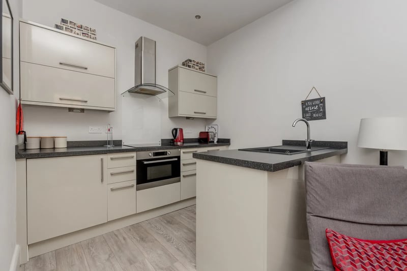 The modern kitchen includes a hob, oven, dishwasher, fridge and washing machine in the asking price