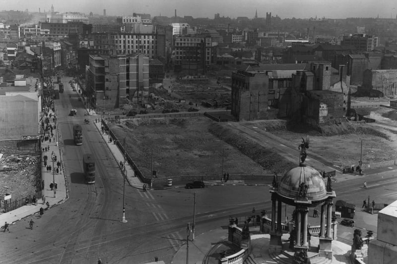 Trams run past the Queen Victoria statue in a bombed out Liverpool city centre in 1945.
