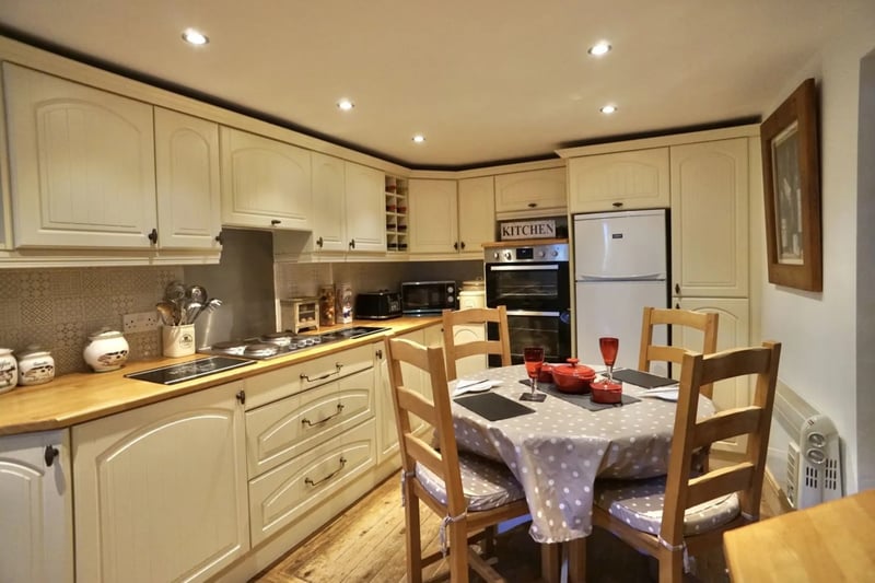 The kitchen has integrated appliances and room for a dining table.