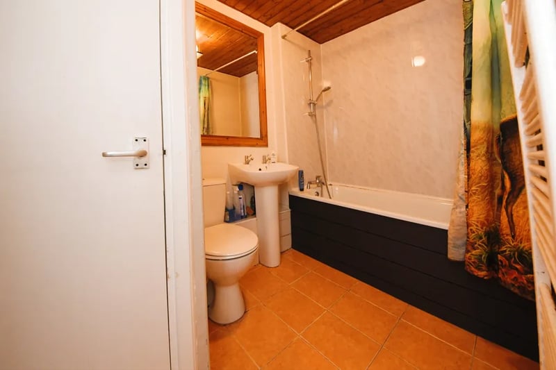 The bathroom has tiled floors and a combined bathtub/shower for those who enjoy bubbles before bedtime