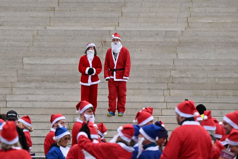 Two Santas are a step ahead of the rest. (Photo by OLI SCARFF/AFP via Getty Images)
