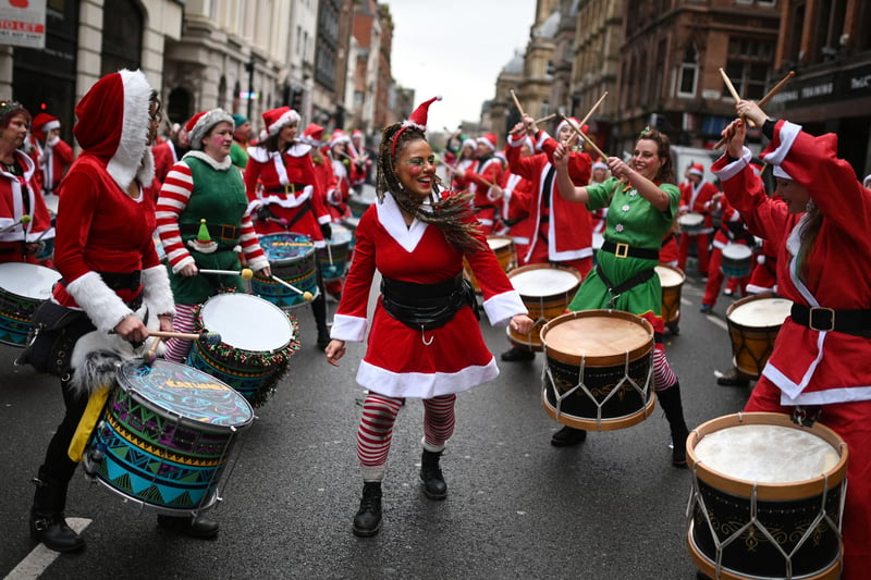 A drumming band dressed in festive attire perform to motivate runners. (Photo by OLI SCARFF / AFP) (Photo by OLI SCARFF/AFP via Getty Images)