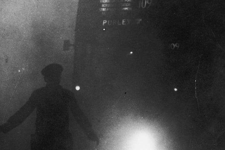 A London bus conductor is forced to walk ahead of his vehicle to guide it through the smog, December 9 1952. Credit: Getty Images