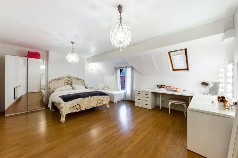 A double bedroom has chandeliers and plently of space for getting dressed.