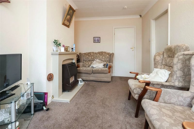 The reception room has been newly fitted with carpets but retains it’s classic era of 70s terrace housing design - including an original gas fireplace