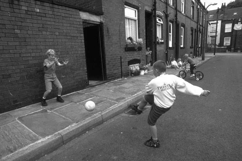 A young boy in a Leeds United jumper takes shots at a friend on the streets of Leeds in August 1997.