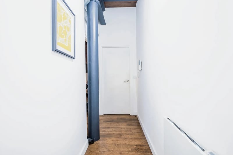 L-shaped hallway with exposed industrial pipe.