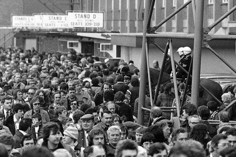 Crowds of Leeds United fans are going to the match in 1980.