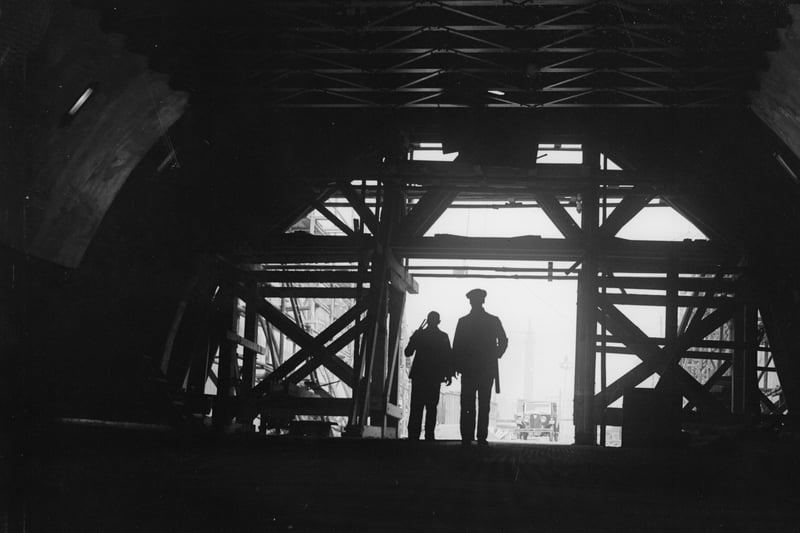 Two workmen stand framed in the entrance to the nearly-completed Mersey Tunnel in April, 1934. Image: Fox Photos/Getty Images