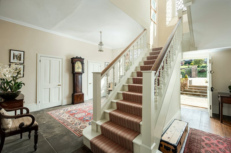 The main house boasts an impressive wooden staircase leading up to windows overlooking the courtyard