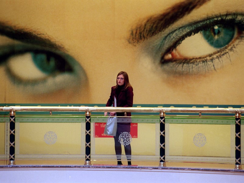 The eyes have it... A lone shopper looks out over a balcony at the somewhat bewildering array of shops during the opening day of the Trafford Centre in Manchester.