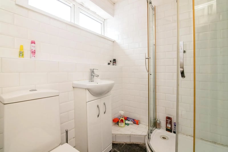 The bathroom features an in built shower and sink.  