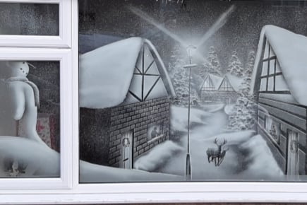 Another stunning rustic winter scene rendered in snow art on a window