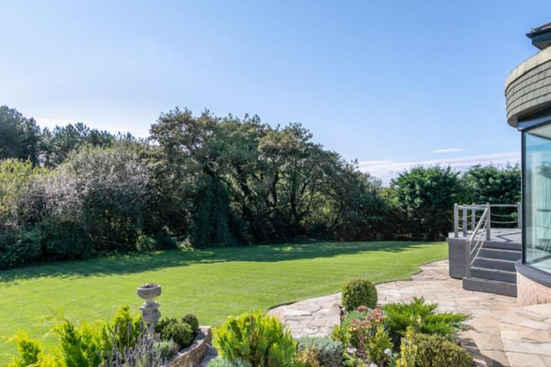 The property stands in a generous plot behind private and secure electric gates, with parking for several vehicles, a garage with extensive storage, manicured lawns and shrubs.