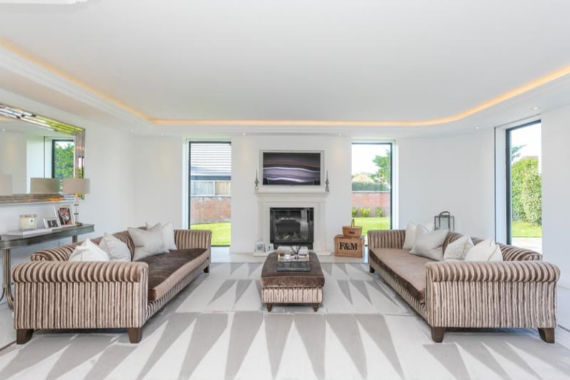 The large living room is filled with natural light, as well as modern ceiling lighting.