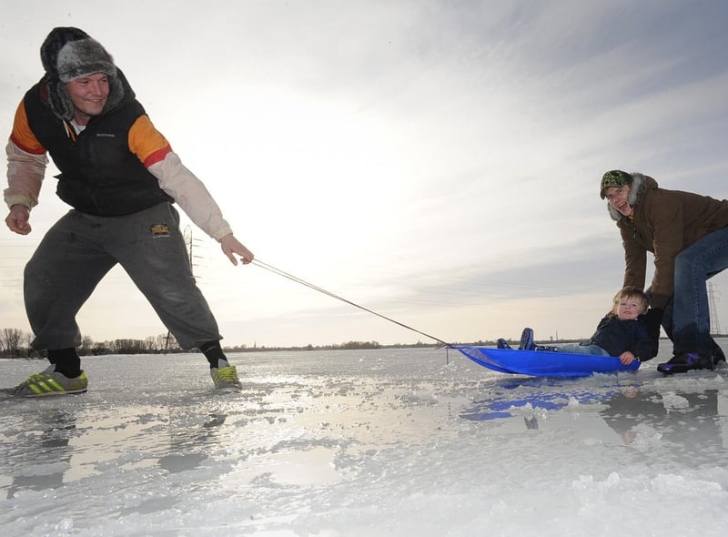 Kayne Worlding, 2, out on the ice at Whittlesey Wash with mum Kym Worlding, 26 pushing and dad Wayne Daniels, 28, pulling in 2013.
