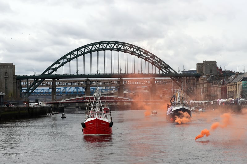 A flotilla of fishing vessels passes under the Tyne Bridge in Newcastle, northeast England on April 8, 2018, during a protest against the Brexit transition deal that would see Britain continue to adhere to the Common Fisheries Policy after formally leaving the EU.