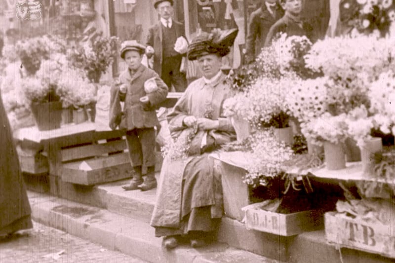 This image shows a flower stall at Stockport market circa 1910