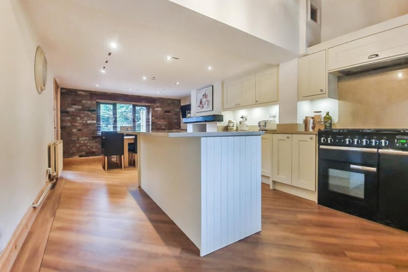 The kitchen/diner is open plan, with wooden floors and an island worktop plus wood burning island.