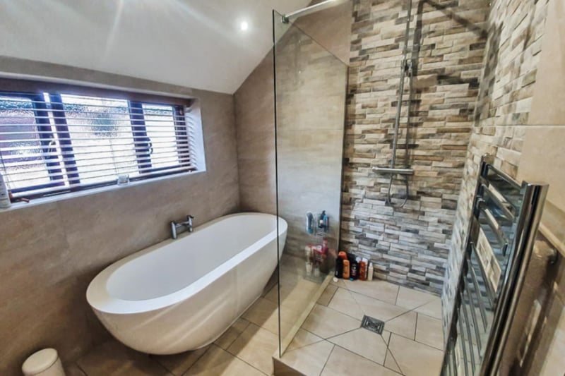 The large family bathroom features a walk-in shower and standing bath tub.