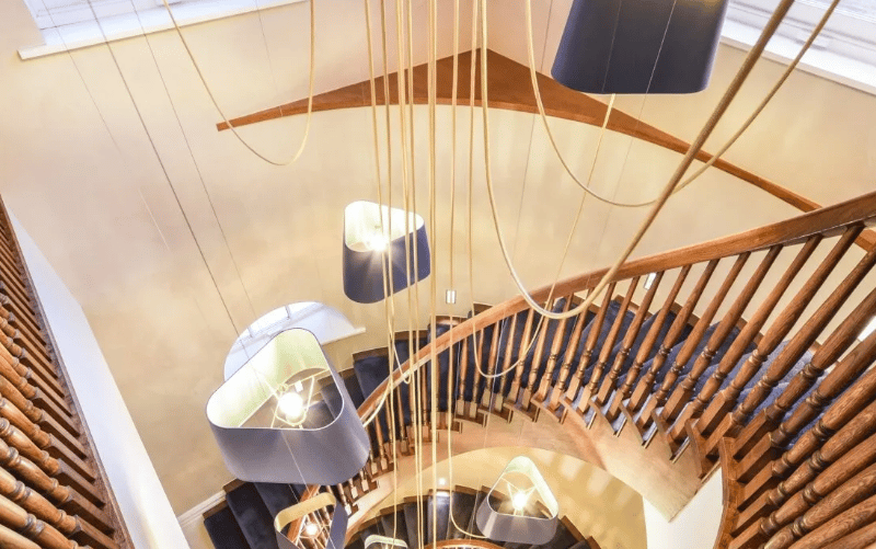 First view of the inside, showcasing a vast light fixture and a spiralling staircase