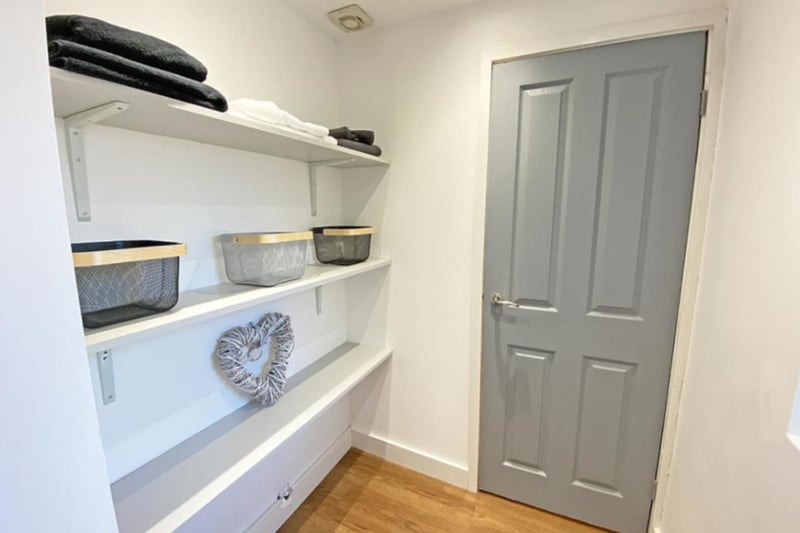 There is a utility room with storage space and a sink.