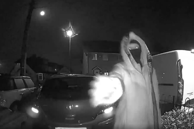 This masked person attempts the front door of a property before running away 