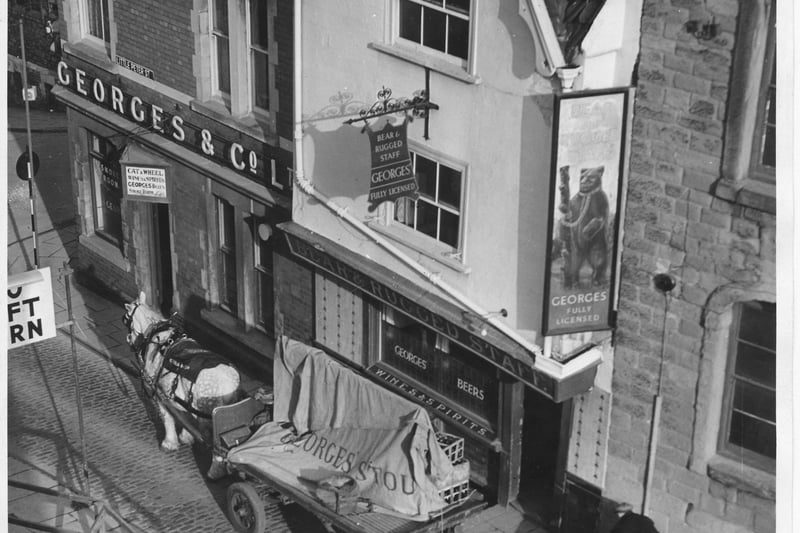 This image shows a a horse dray delivery at the Bear & Rugged Staff,  c.1956. Both the Bear & Rugged Staff and neighbouring Cat & Wheel were demolished to make way for the creation of Castle Park when the city’s shopping centre was moved to Broadmead. The Bear once backed hard against the outer wall of the medieval castle in Castle Park today.