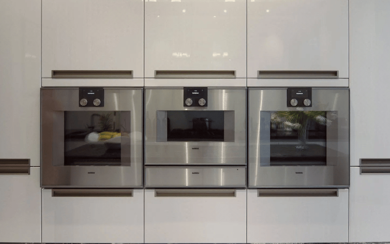 A closer view at the heart of the kitchen, with built ovens at waist height for must