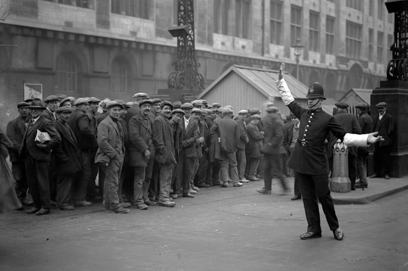   London tram workers queue up for their pay at the tram subway in Kingsway, High Holborn on April 7 1930