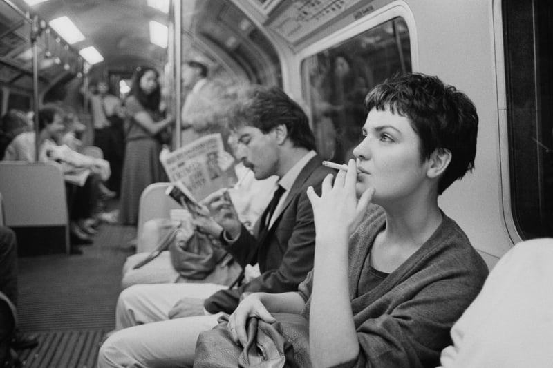 A woman smoking a cigarette on a London Underground train, London, June 21 1984.