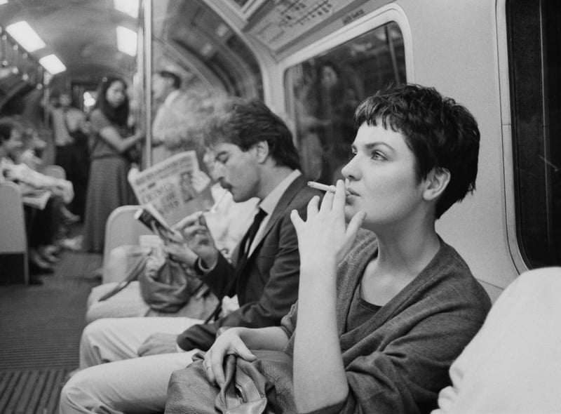 A woman smoking a cigarette on a London Underground train, London, June 21 1984.