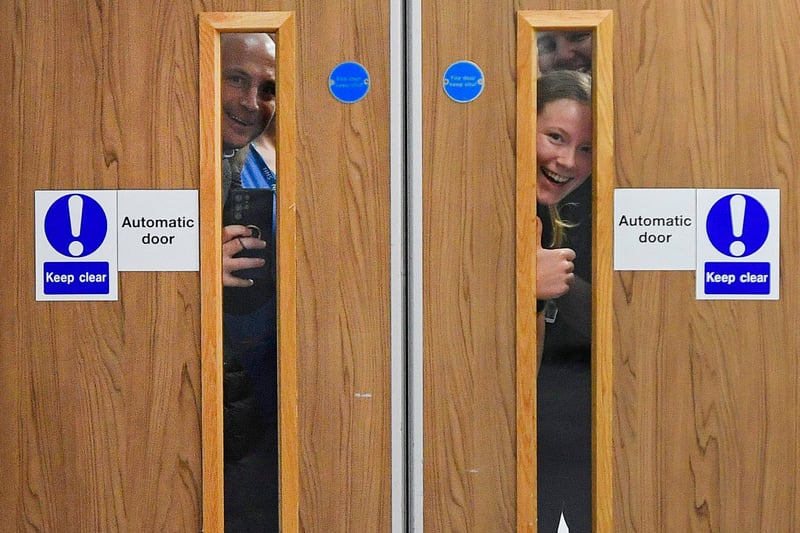 Hospital staff try and get a glimpse of Prince William, Prince of Wales and Catherine, Princess of Wales during a visit to the Royal Liverpool University Hospital.
