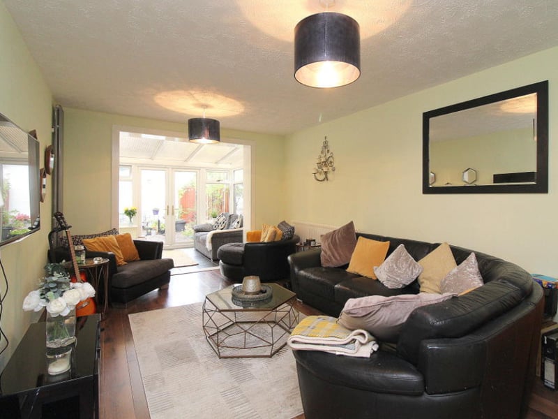 The spacious living room leads to a conservatory.