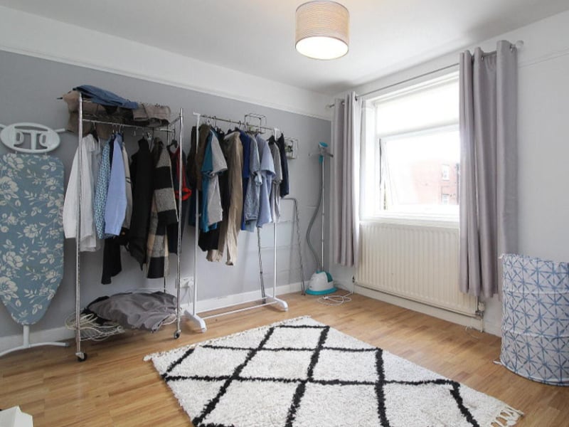 The second double bedroom is currently used as storage. A large window fills the room with light.