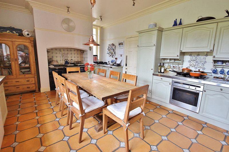 The kitchen and family sitting room has hand painted cabinets, built-in appliances and a four oven Aga.