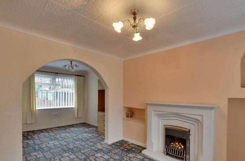 The first image of the inside of the property showcases a fireplace and the potential for an open plan main room