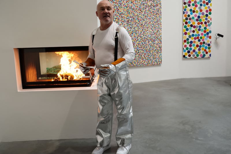 Believed to be the UK’s richest living artist, Damien Hirst was born into a working class family in Bristol. He soon moved to Leeds and later studied fine art at Goldsmiths College in London. He’s pictured holding an art piece before burning it during at the Newport Street Gallery in London,  as part of his exhibition “The Currency”, a project for which the artist set on fire paintings after having selling them in digital form.