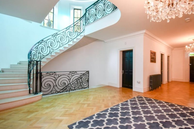 The property opens into a spacious entrance hallway, with parquet flooring and adjacent cloakroom.