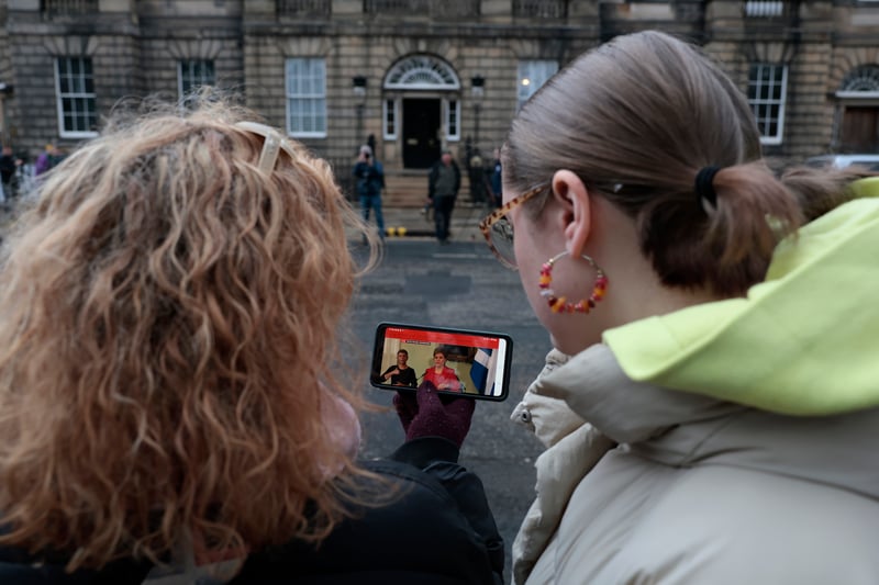 People watched the press conference on mobile phones as they gathered outside of Bute House.
