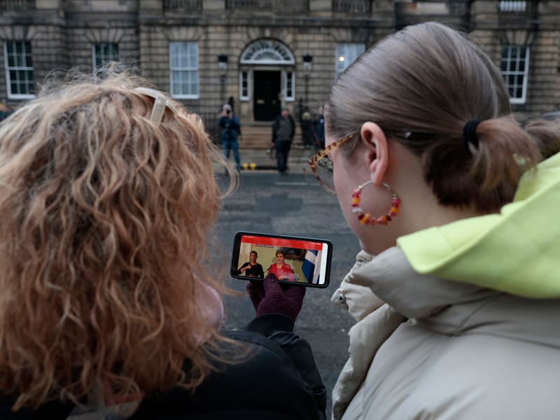 People watched the press conference on mobile phones as they gathered outside of Bute House.