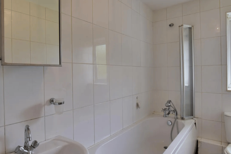 A standard bathroom pictured, with a sliding water protector to add space