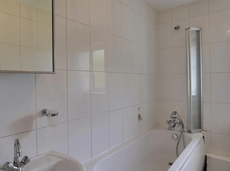 A standard bathroom pictured, with a sliding water protector to add space